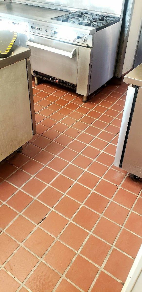 Grout cleaning in progress with taped grid lines